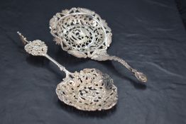 A late Victorian imported silver decorative straining spoon, pierced and engraved throughout,