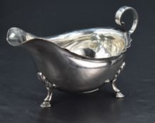 An Edwardian silver gravy boat, of traditional design, having a short flared rim, generous spout and