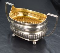 A George III Regency period silver sugar bowl or sucriere, of rounded rectangular form with reed