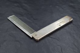 A George V silver mounted and folding moustache comb, of oblong form with engine-turned