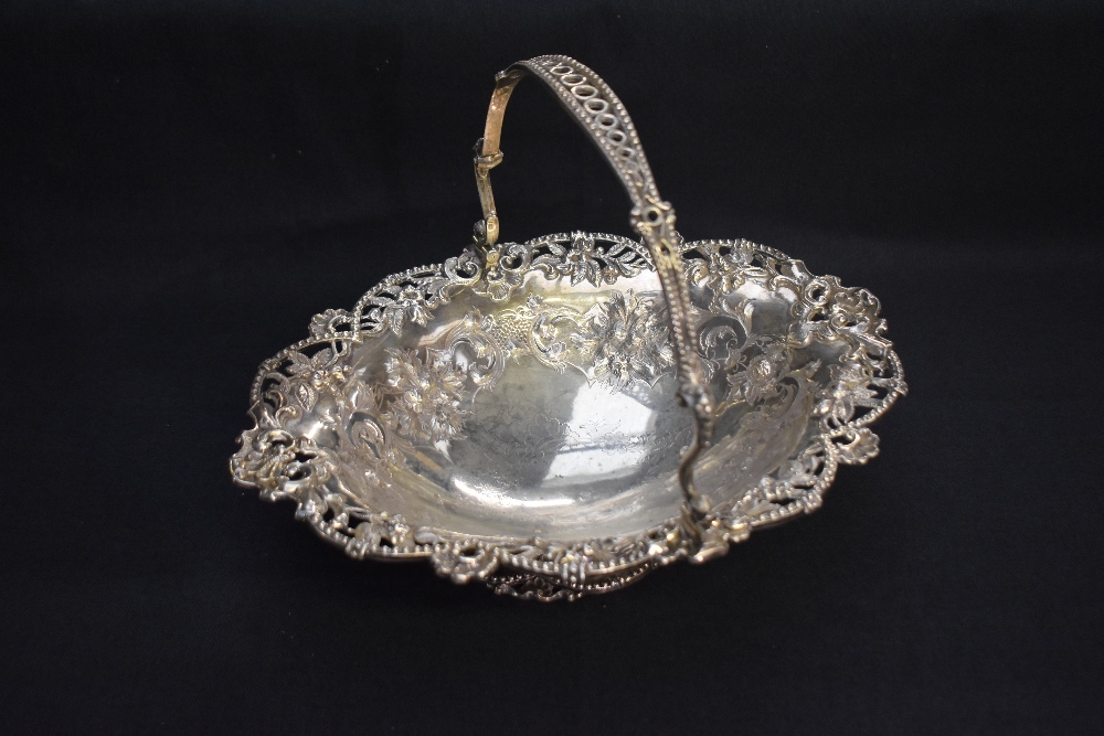 A Victorian silver basket, of oval form with pierced and bead-moulded pivoted handle, over the