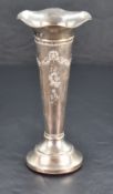 An Edwardian silver trumpet vase, with flared and ruffled rim over the tapering body embossed with