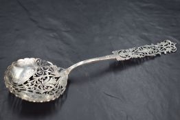An attractive Edwardian silver straining spoon, the circular bowl and elongated terminal nicely