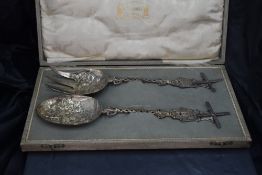 A cased set of Dutch white metal salad servers, the spoon with oval bowl, the of four tined shaped