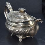 A George III silver teapot, of moulded oval form with foliate embossed finial topped, domed and