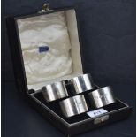 A cased set of four George V silver napkin rings, of plain cylindrical form with marks for