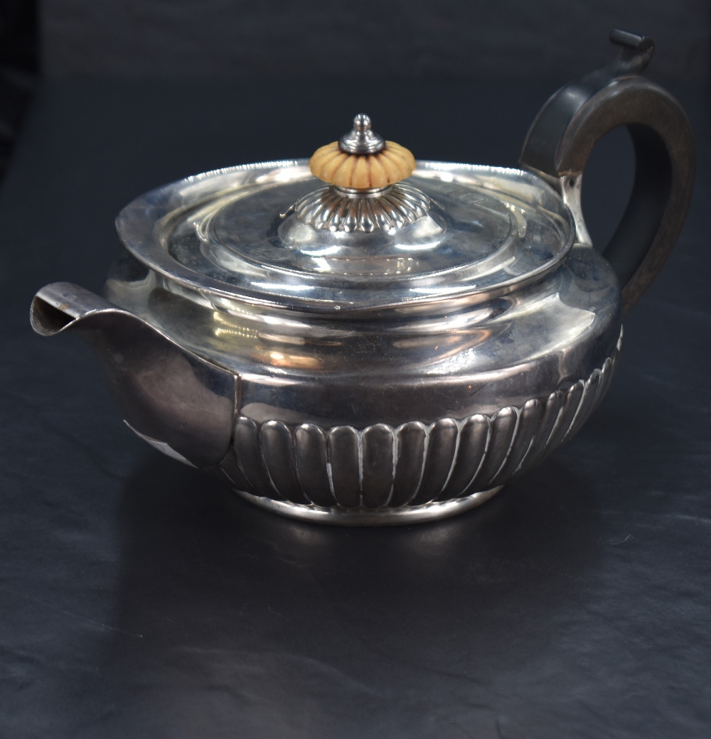 A George III silver teapot, of circular form with domed fluted and ivory finial knopped cover over