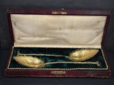 A pair of German gilt .800 grade white metal spoons, of naturalistic leaf and stem design, marked