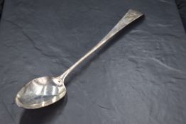 A George III silver Old English pattern long handled serving spoon, the terminal engraved with crest