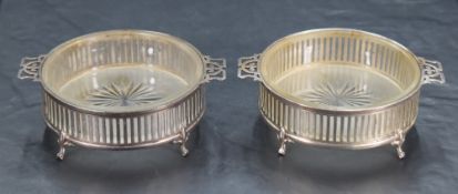 A pair of George V silver and frosted glass table salts, of circular form with two pierced strap-