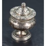 A 19th century silver pepperette, the stepped, domed and pierced finial-topped cover over a