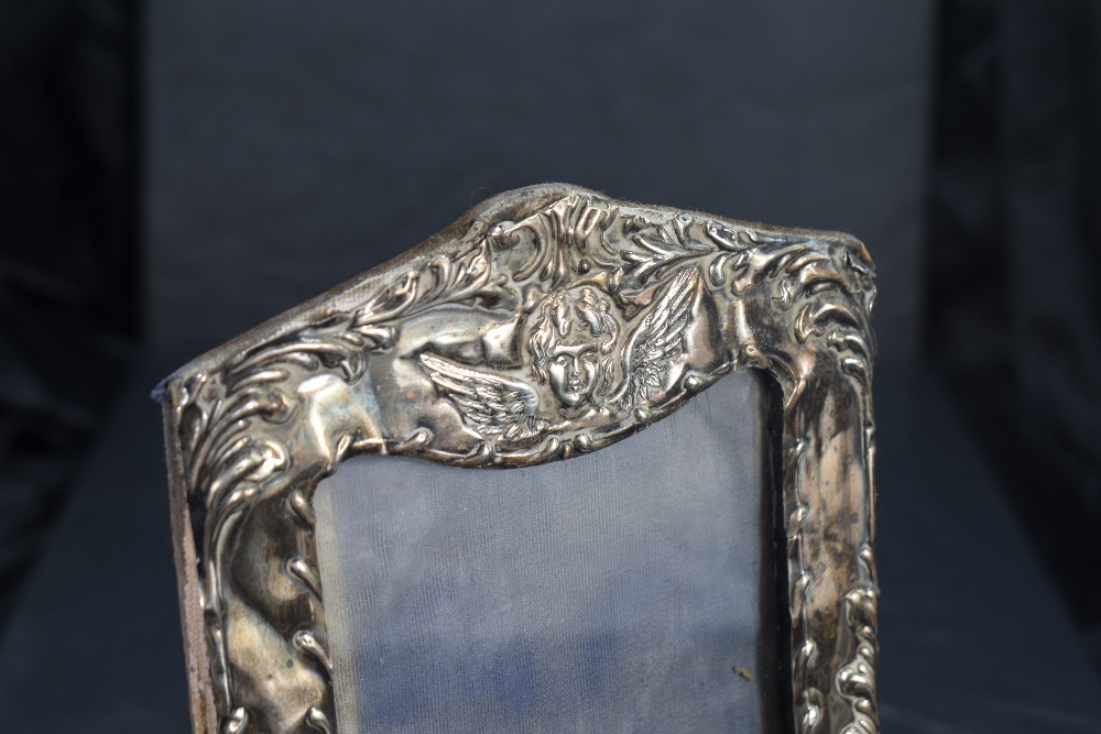 An Edwardian silver-mounted photograph frame, of shaped rectangular form embossed with foliate - Image 2 of 3