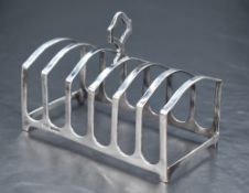 A George V silver six-division toast rack, of arched form with central carrying handle, marks for