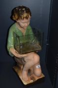 An early 20th Century kitsch and chalkware advertising figure with glass jar, measuring 54cm tall