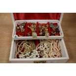 A tooled leather jewellery box containing assorted jewellery, including simulated pearls, gold