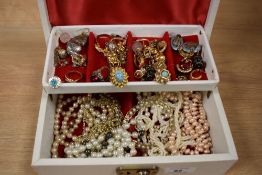 A tooled leather jewellery box containing assorted jewellery, including simulated pearls, gold