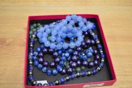 An assorted collection of coloured glass beads, including wedding cake style bead necklace