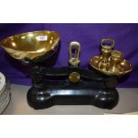 A set of late 19th/early 20th Century black painted kitchen scales with brass weights