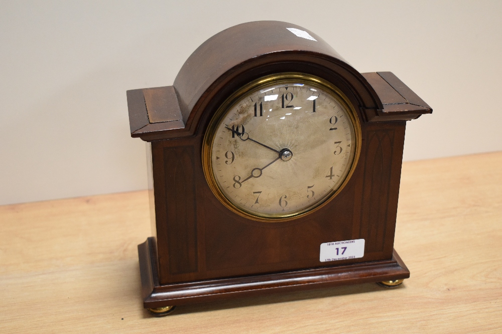 A 19th Century French bonnet top mantel clock, having a silvered Arabic dial, within a mahogany