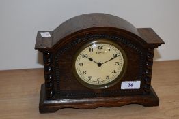 An early 20th century oak mantle clock, having an enamelled Arabic dial, 8 day Swiss movement, and