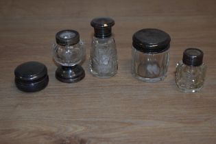 A collection of cut glass scent and dressing table jars, with silver and white metal mounts/lids,