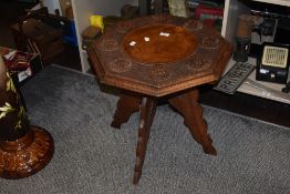 A 19th/20th Century mahogany tripod table, of Indian design, the heavily carved octagonal top