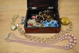 An oriental lacquered jewellery box containing assorted costume jewellery, including strings of
