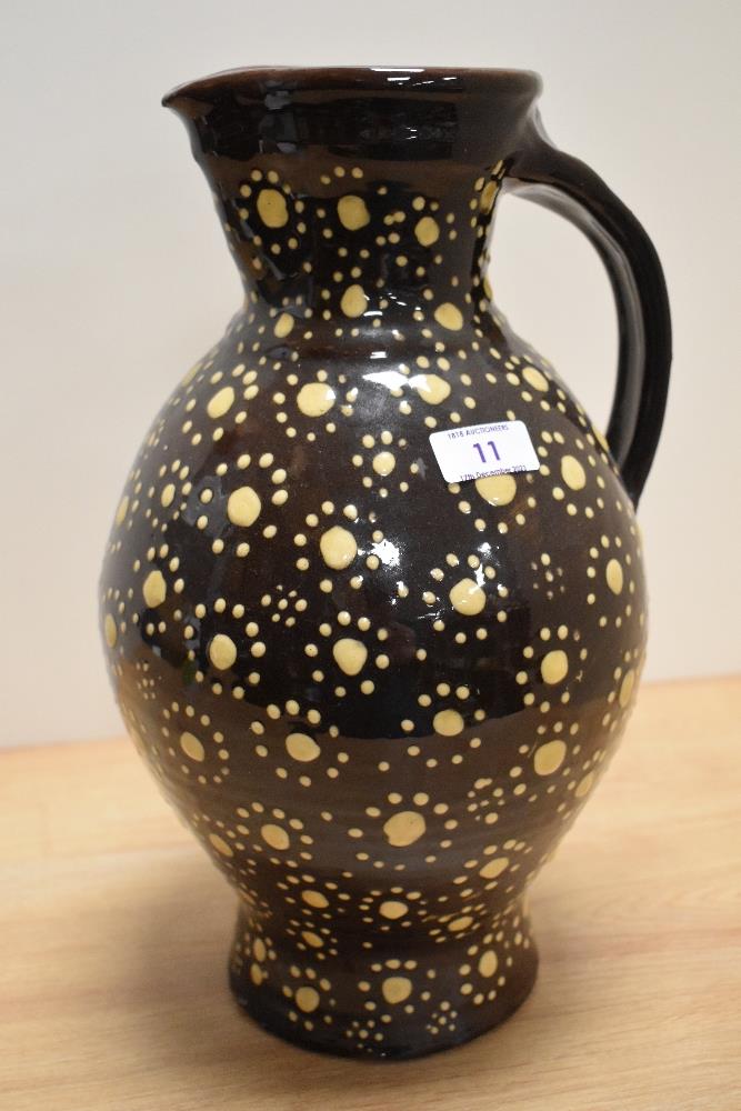 A Wetheriggs style pottery vase or jug, dark brown glaze, and measuring 36cm tall