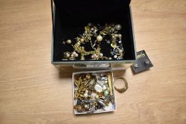 A mirrored jewellery box containing assorted costume jewellery, including gold coloured,