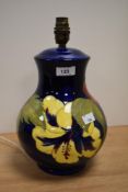 A William Moorcroft Hibiscus patterned lamp base on blue ground, measuring 30cm tall