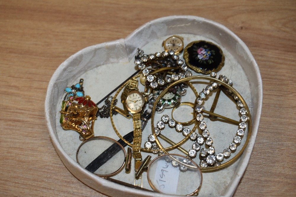A heart shaped box containing assorted jewellery, including a yellow metal textured bangle, an