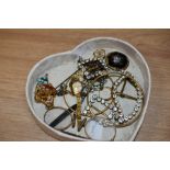 A heart shaped box containing assorted jewellery, including a yellow metal textured bangle, an