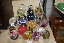 An assorted collection of glass paperweights and ornaments, including Phoenician Glass and a