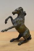 A patinated solid brass rearing horse ornament, measuring 21cm tall