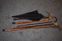 A collection of walking sticks and parasol, to include silver-mounted walking stick, horn handled