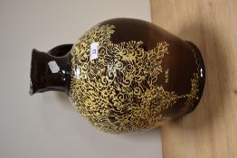 A Wetheriggs style slip glazed ewer or jug, on dark brown glazed grown, measuring 38cm tall