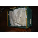 A box of assorted laced worked items, including table cloths