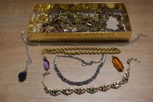 A variety of ladies costume jewellery, including amber glass pendant and necklaces.