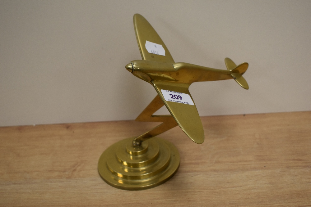 A vintage solid brass fighter plane ornament on stepped base, measuring 18cm tall