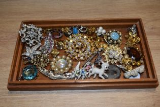 A small collection of costume jewellery brooches, including a yellow metal starburst style brooch,