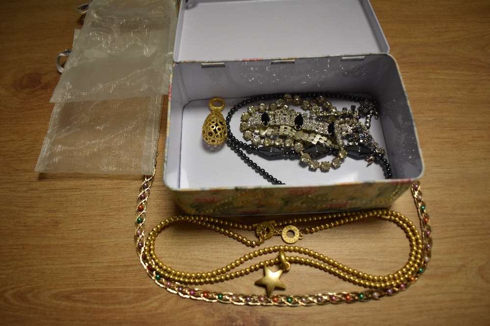 A tin of costume jewellery, including Sence Copenhagen star pendant and chain, plus other decorative