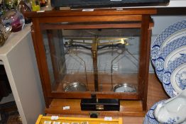 A cased set of vintage brass balance scales, displayed within a glazed mahogany case, dimensions