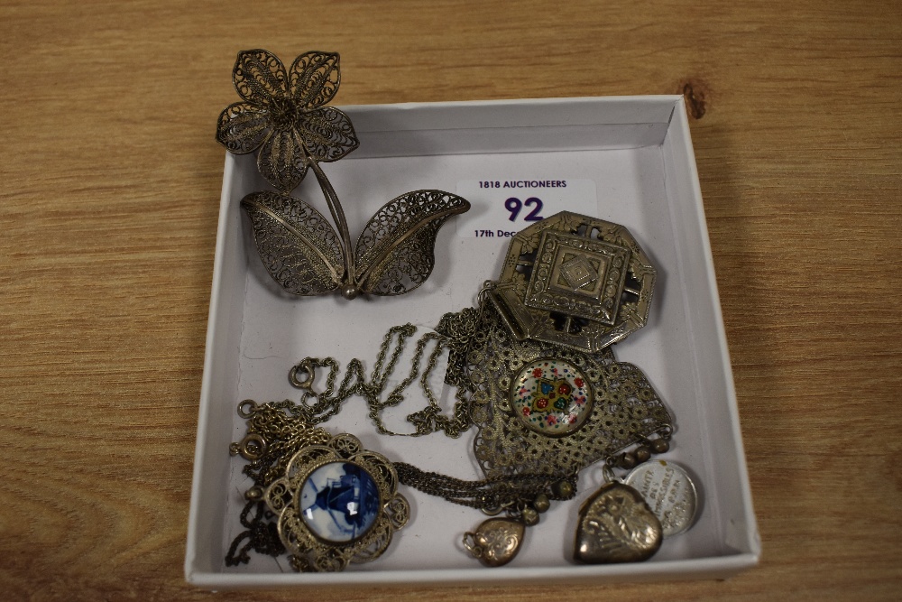 An assorted collection of white metal jewellery, including filigree pendants, a Delft porcelain