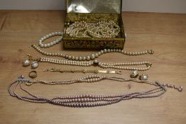 A tin of simulated pearl necklaces and costume jewellery, including clip on earrings and rings