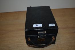 A black leather compartmented jewellery box with mirrored interior, measuring 10cm tall