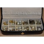 A black leather Rowallan jewellery box containing pearl style earrings, stud earrings, and others