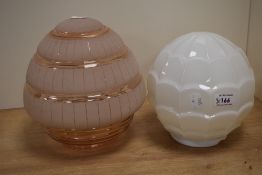 Two vintage lamp shades, including moulded opaque shade and pink frosted shade.