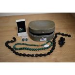 A vintage jewellery case containing a string of mourning beads, brooch, string of malachite beads