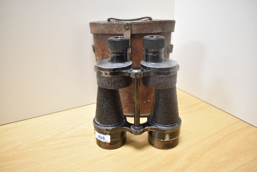 A pair of Bino Prismatic No5 MkIII X7 binoculars bearing the military crowsfoot mark in leather