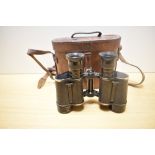 A pair of Dollond, London Prismatic X6 binoculars bearing military crowsfoot mark in leather case